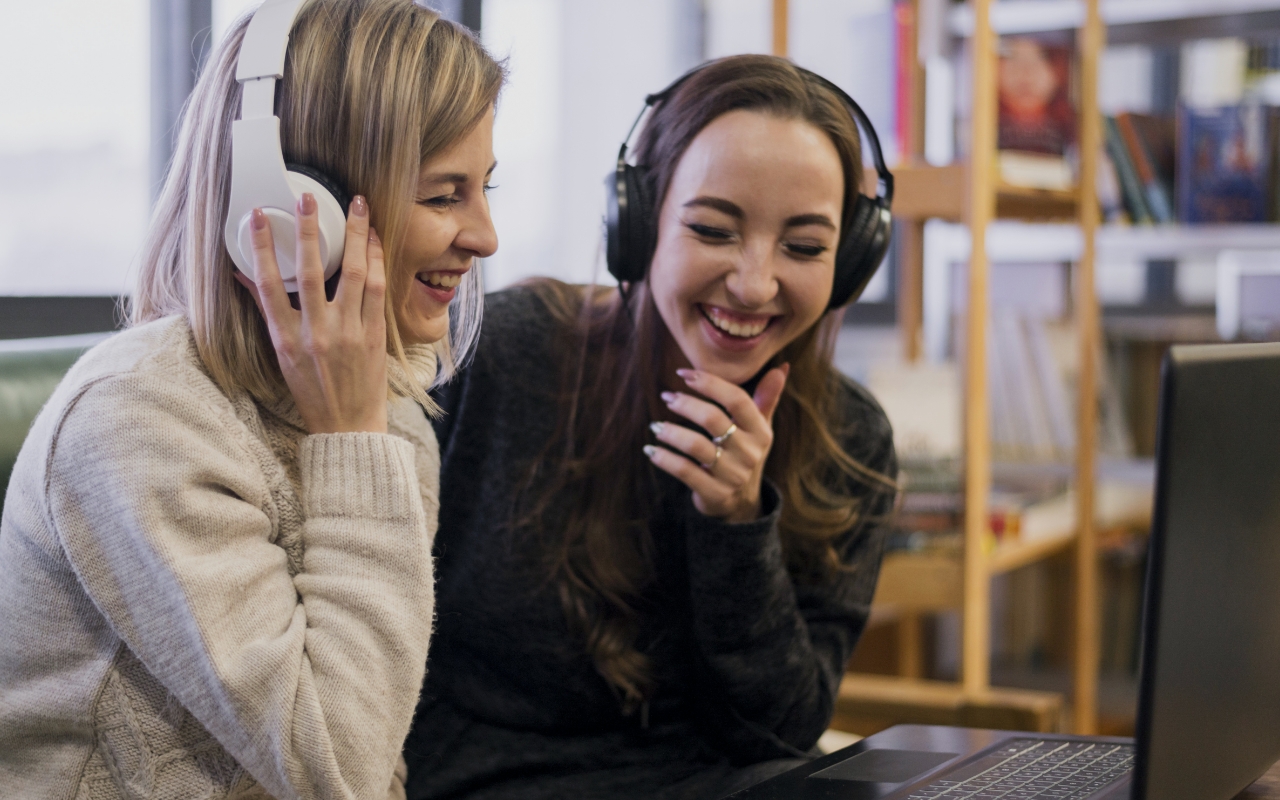 dwie kobiety przed komputerem słuchają personalizowanej piosenki prezentowej
